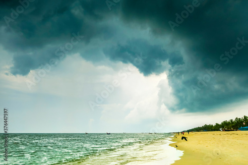 Dark late Monsoon rain cloud and ubiquitous house crows at popular Marari Beach, Mararikulam, Alappuzha (Alleppey, Kerala, India, Asia photo