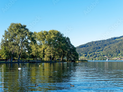 Along the promenade on the beach of Bad Wiessee with view on the lake of Tegern and the shore of Gmund am Tegersee
