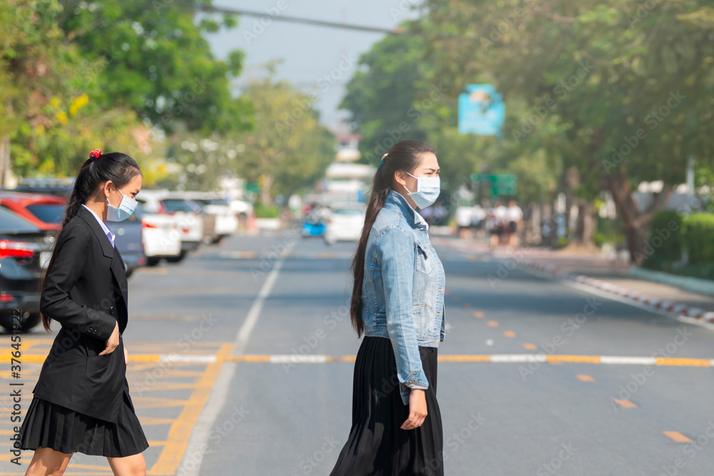 Asian woman wearing the N95 Respiratory Protection Mask against covid19, air pollution at road and traffic.