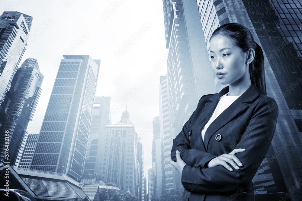 Prosperous Asian businesswoman in suit in crossed arms pose. Singapore cityscape. The concept of woman in business. Financial downtown. Double exposure. Prosperous Asian businesswoman in suit in crossed arms pose. Singapore cityscape. The concept of woman in business. Financial downtown. Double exposure.