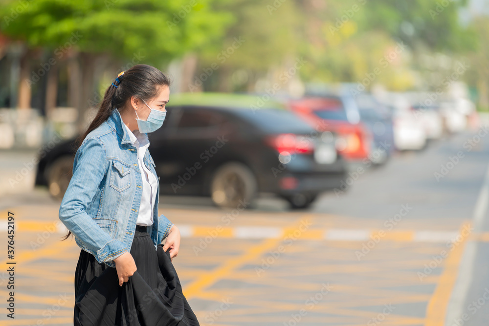 Portrait of young girl walking wearing a mask in the city street. Protection covid19, against flu, pollution, contagious diseases.