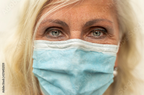 Gorgeous European woman wears a face mask to protect herself from coronavirus.