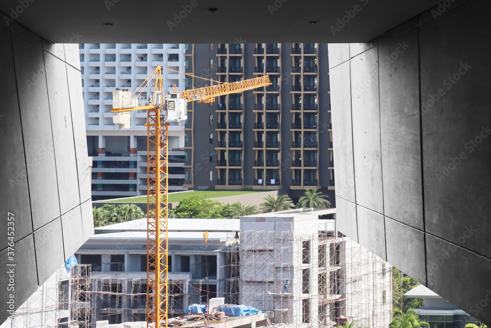 Perspective view of yellow tower crane working on construction site ...