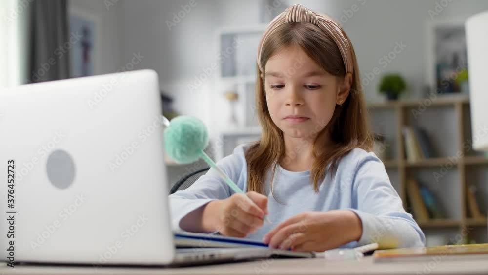 The girl writes in a notebook. Distance learning, school online. The girl writes in a notebook. Distance learning, school online.