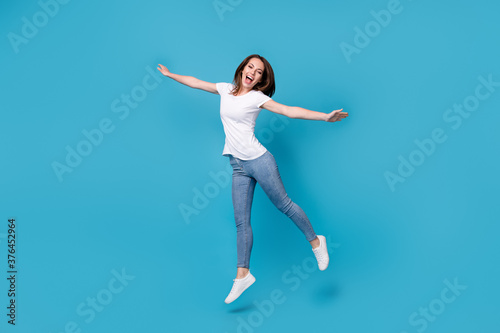 Full length body size view of her she attractive pretty funky skinny overjoyed cheerful cheery girl jumping having fun wear comfort clothes isolated bright vivid shine vibrant blue color background