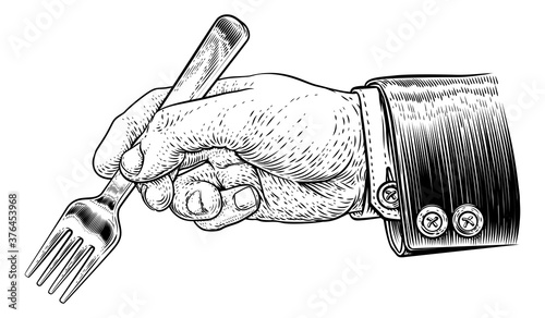 A hand in business suit holding a fork for eating food in a vintage retro engraved or etched woodcut print style