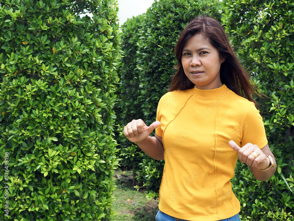 Asian women wearing yellow shirts With a finger pointing. Asian women wearing yellow shirts With a finger pointing.