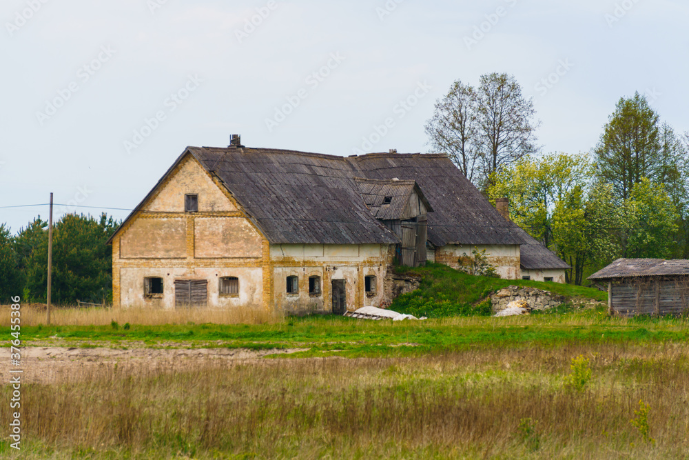 Very old abandoned agricultural buildings of the 19th century in a Latvian village, May 2020.