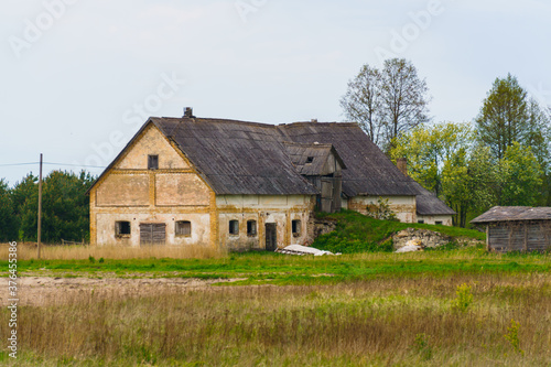 Very old abandoned agricultural buildings of the 19th century in a Latvian village, May 2020.