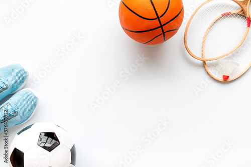 Flat lay of sport balls and rackets on white background. Above view, copy space