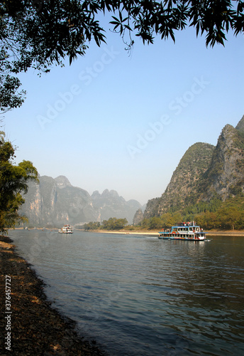Boats on the Li River between Guilin and Yangshuo in Guangxi Province, China. The karst hills and river scenery have provided inspiration for artists and poets. Li River scenery, Guilin.