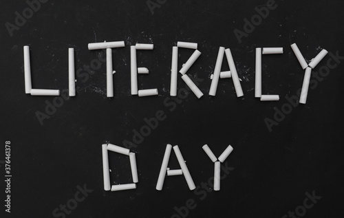 Literacy Day Written with White Chalk Pieces on Black Background