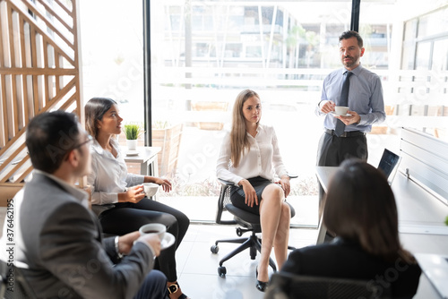 Businesspeople discussing during coffee break in office
