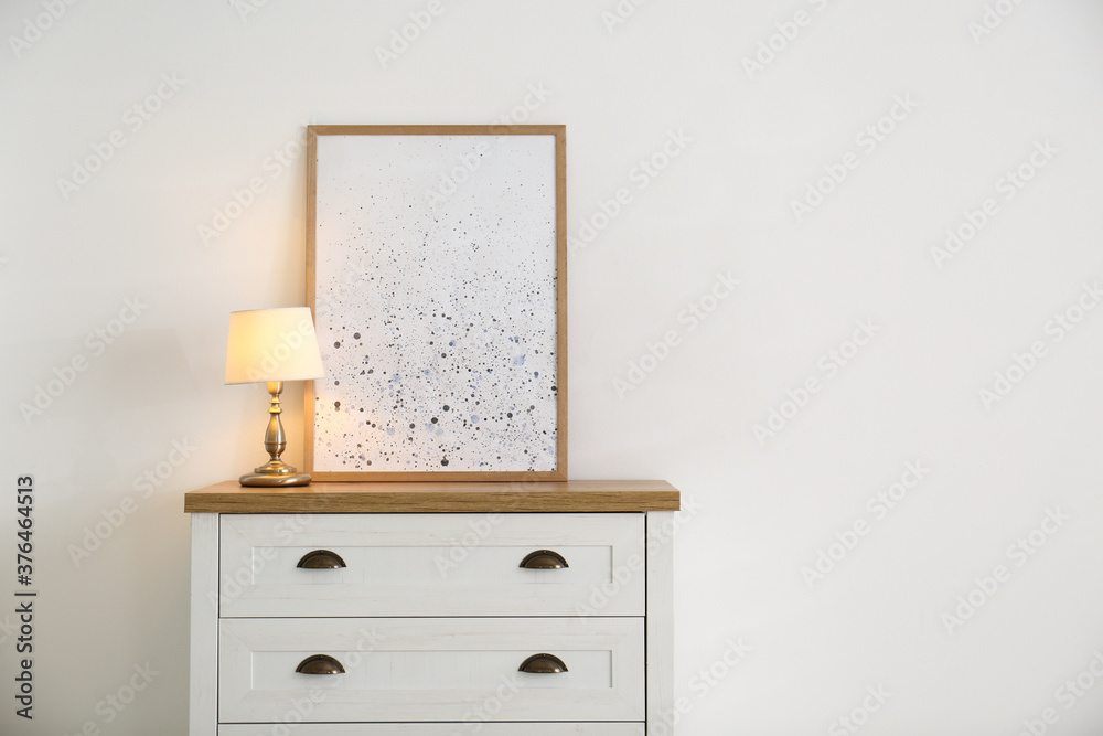 Stylish chest of drawers with lamp in living room Stylish chest of drawers with lamp in living room