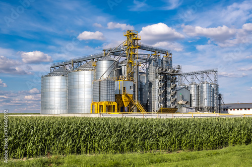 Modern Granary elevator. Silver silos on agro-processing and manufacturing plant for processing drying cleaning and storage of agricultural products, flour, cereals and grain.