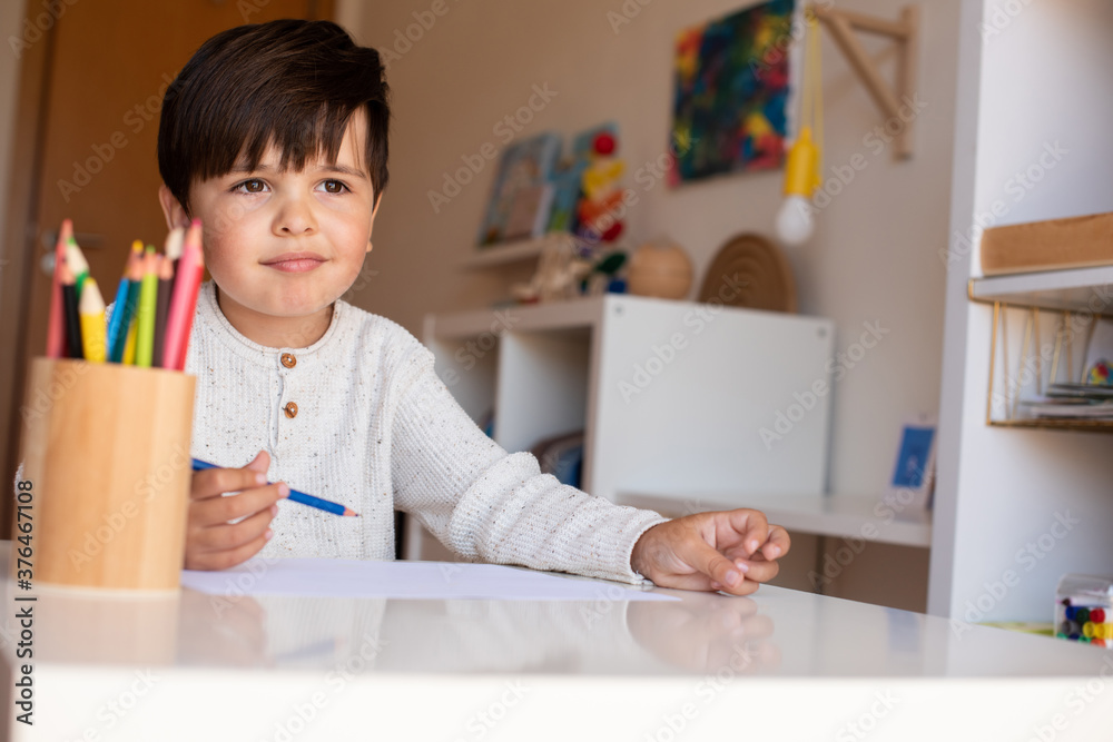 Preschooler kid drawing with coloured pencils. Homeschooling. Learning community. Montessori school. Preschooler kid drawing with coloured pencils. Homeschooling. Learning community. Montessori school.