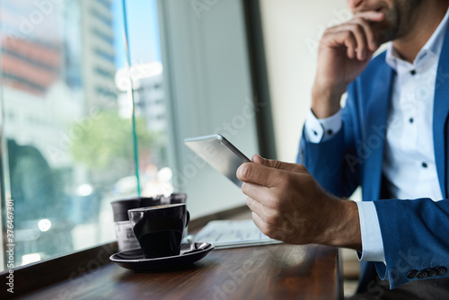 Businessman using a tablet over coffee in a cafe