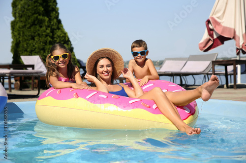 Woman with her children in swimming pool. Family vacation