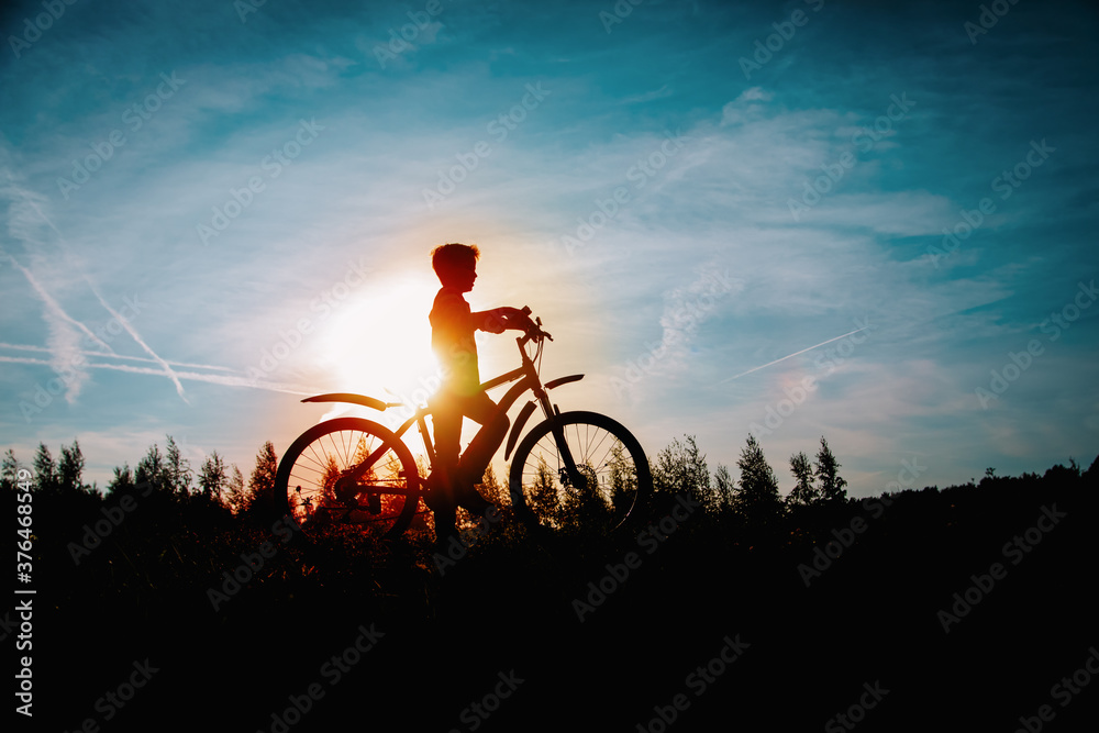 Obraz premium happy kid riding bike at sunset nature