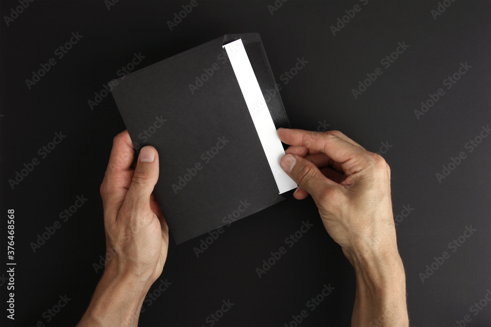 hands holds blank black envelopes with white letter on black background, receive post message, mockup, copy space hands holds blank black envelopes with white letter on black background, receive post message, mockup, copy space