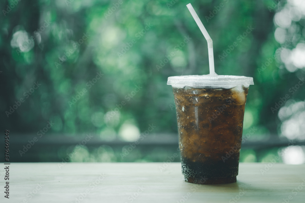 Soft drink in plastic glass with green nature background Soft drink in plastic glass with green nature background