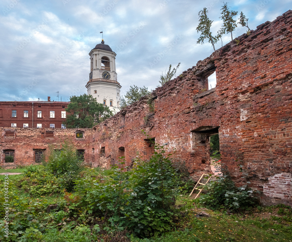 The ancient clock tower in the city of Vyborg Russia through the ruins of an temple The ancient clock tower in the city of Vyborg Russia through the ruins of an temple