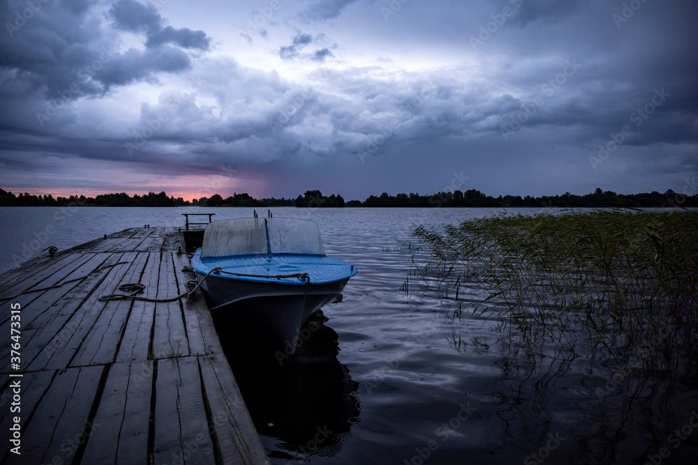 Naklejka premium sunrise over the lake when the sky is covered with rain clouds