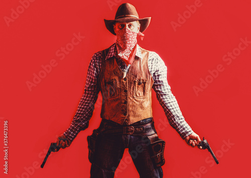 Fotografia Cowboy with weapon on red background