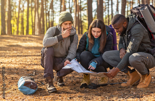 Lost backpackers looking for location, using map photo