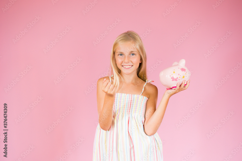 Smiling beautiful blonde girl showing a piggy bank Smiling beautiful blonde girl showing a piggy bank