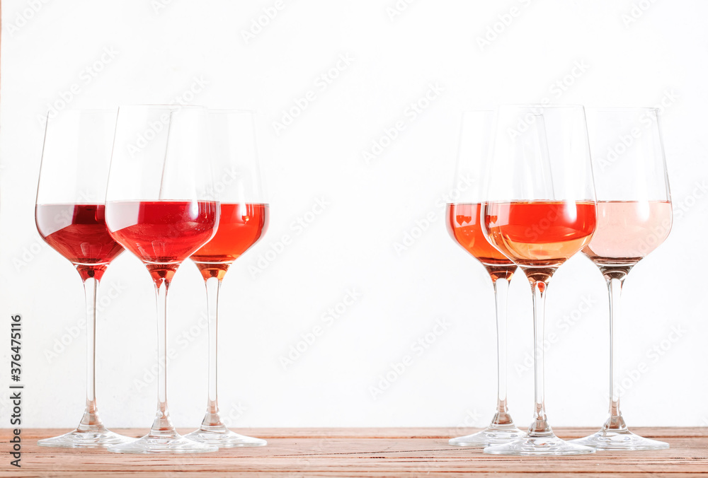 Rose wine glasses set on wine tasting. Tasting different varieties, colors and shades of pink wine concept. White background