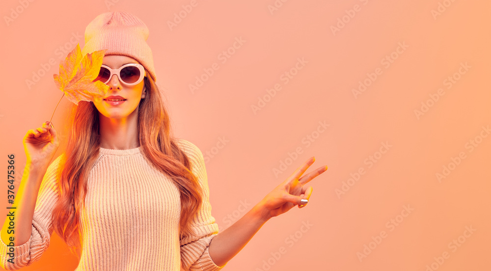 Fashionable hipster woman in Trendy autumn fall outfit, stylish hair, makeup. Blonde model in jumper, fashion jeans having fun smiling. Beautiful girl in autumnal beanie hat with maple leaf - obrazy, fototapety, plakaty 