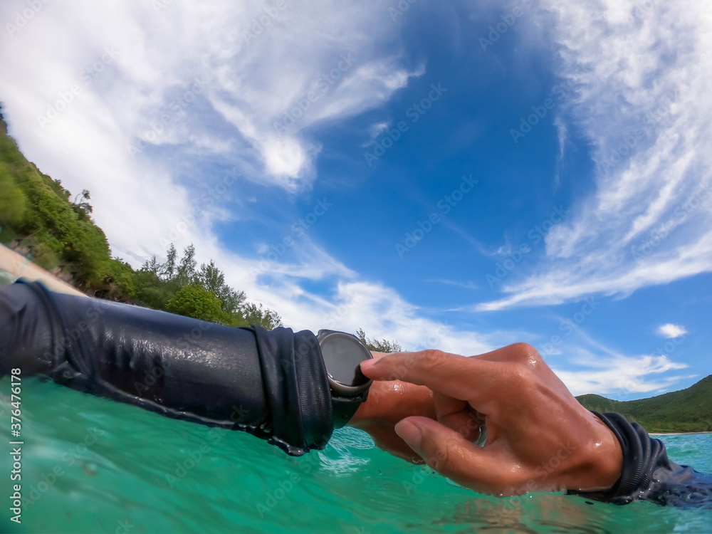 A young guy setting smart watch to save the activity for skin diving