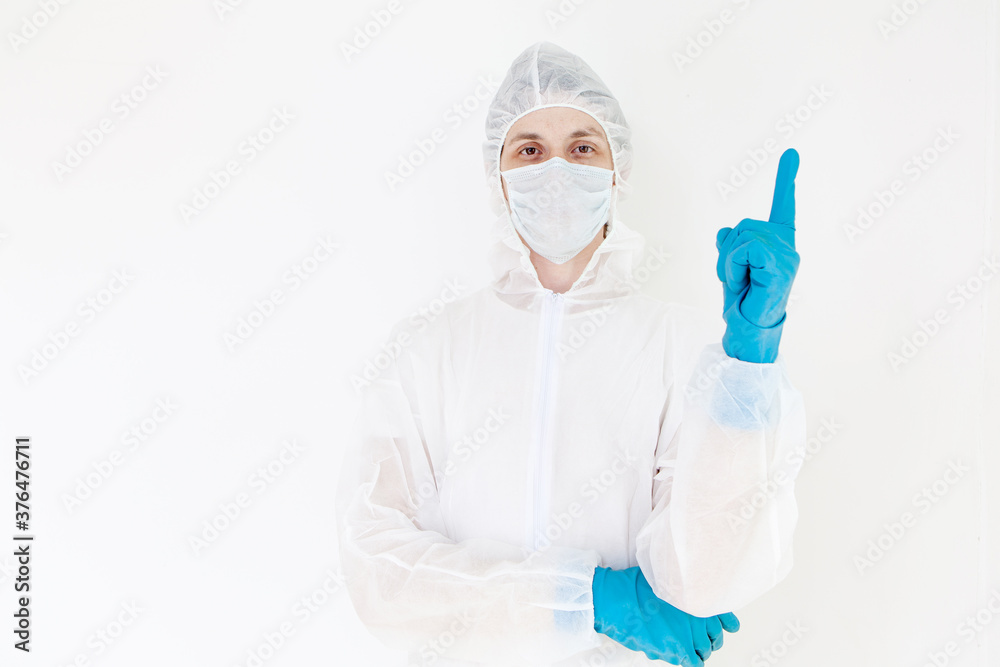 A man in a protective suit and face mask.  Shows the gesture of attention. Isolated on a white background
