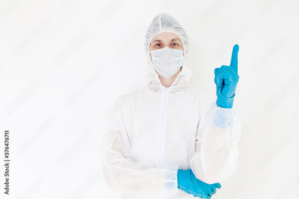 A man in a protective suit and face mask. Shows the gesture of attention. Isolated on a white background A man in a protective suit and face mask. Shows the gesture of attention. Isolated on a white background
