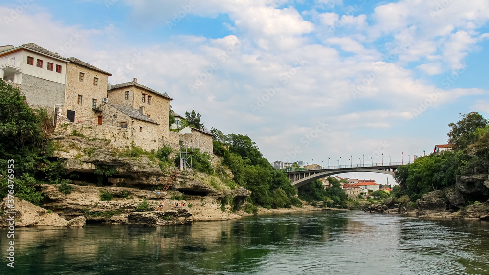 Fototapeta premium The green Neretva River underneath the old bridge in Mostar, Bosnia