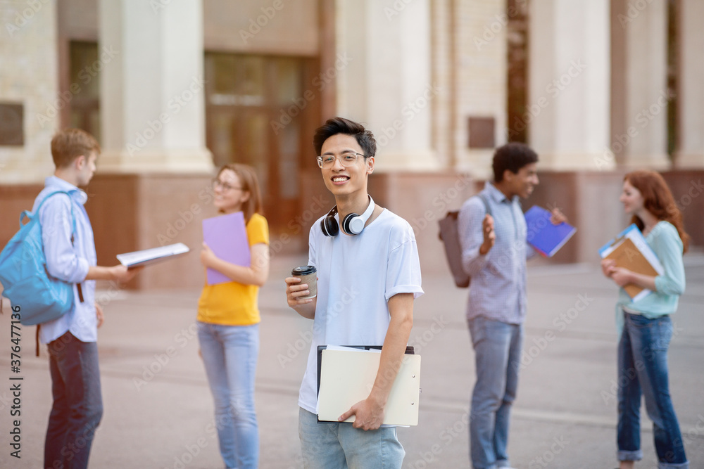 Asian Guy Standing Among Multiethnic Students Near University Building Outside Asian Guy Standing Among Multiethnic Students Near University Building Outside