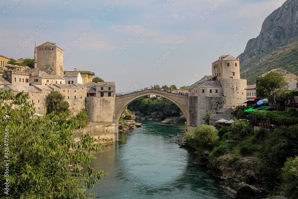 A landscape view of the old town of Mostar, with the old bridge over the river