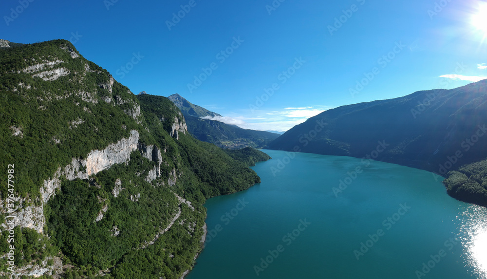 Morning aerial panorama of lake molveno, a beautiful lake in Trentino part of italy, on a clear sunny day with crystal green water visible.