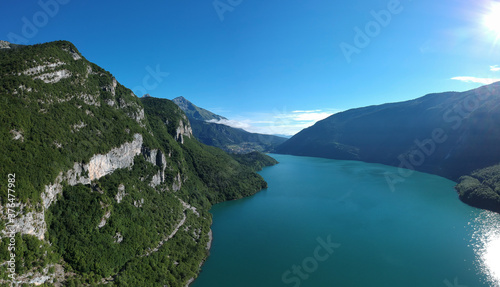Morning aerial panorama of lake molveno, a beautiful lake in Trentino part of italy, on a clear sunny day with crystal green water visible. © Anze