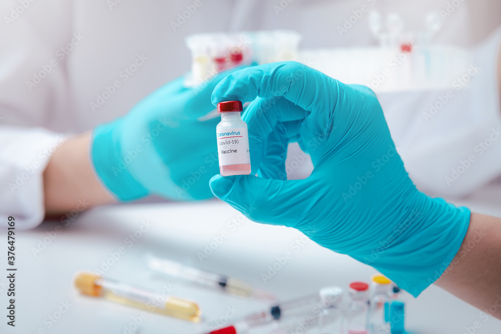Researcher holding vaccine sample in the laboratory. Researcher is inventing vaccines to treat COVID-19 virus. Researcher holding vaccine sample in the laboratory. Researcher is inventing vaccines to treat COVID-19 virus.