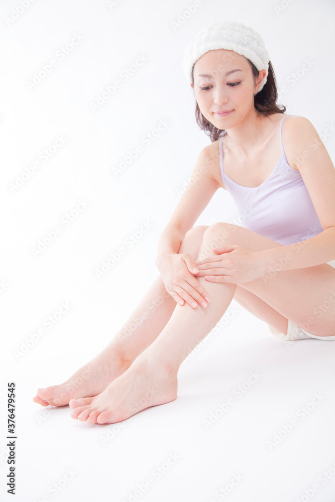足にボディクリームを塗る女性 足にボディクリームを塗る女性