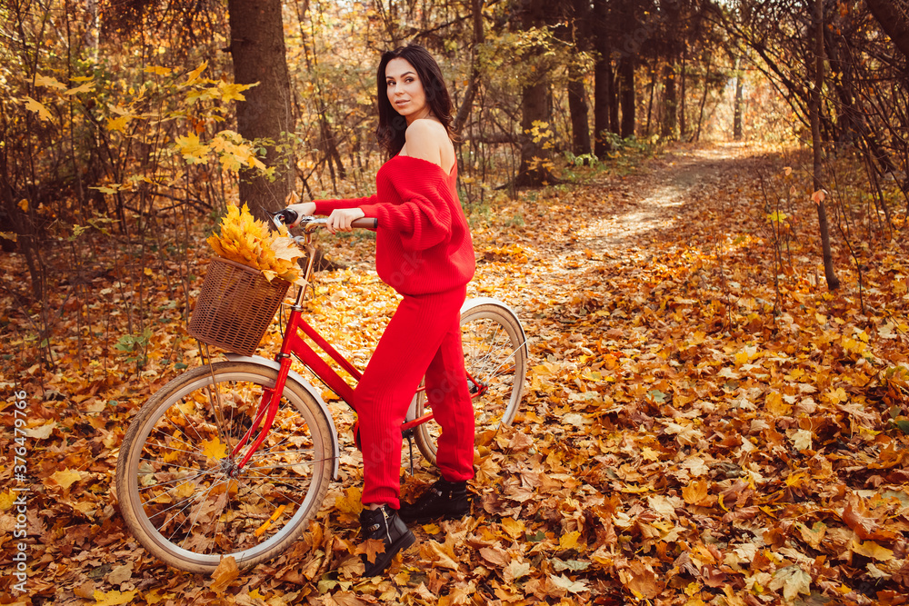 beautiful girl - brunette walks in the autumn forest on a bicycle, golden autumn - obrazy, fototapety, plakaty 