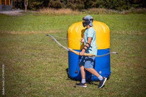 Young boy preparing to shoot arrow during a game of archery tag