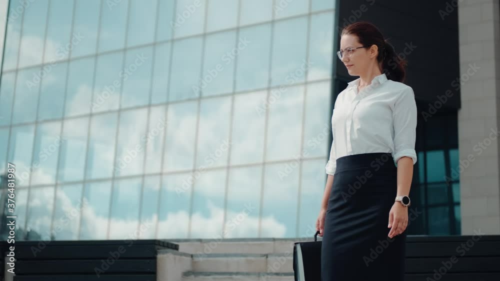 A portrait of a confident business woman who stands and looks into the distance thoughtfully A portrait of a confident business woman who stands and looks into the distance thoughtfully