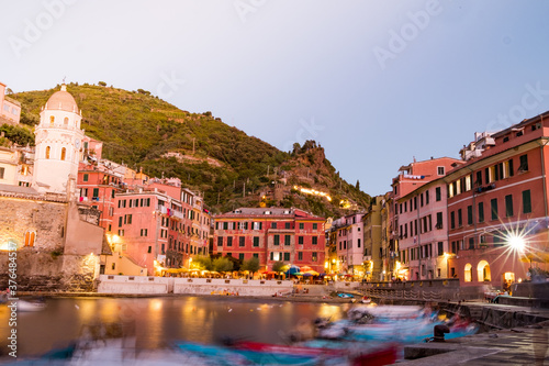 Vernazza town at night, long exposure of the romantic village in CInque terre park at dusk with moving boats