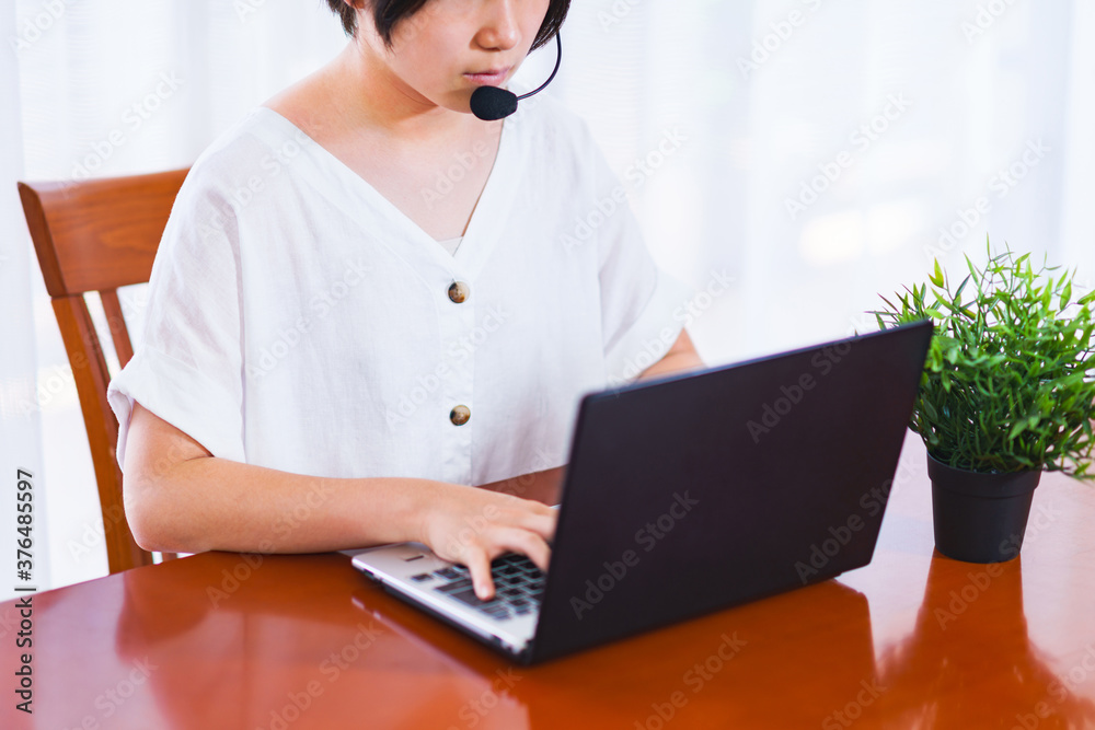 オンラインミーティングをインカムつけて自宅リビングで行う【テレワークのイメージ】