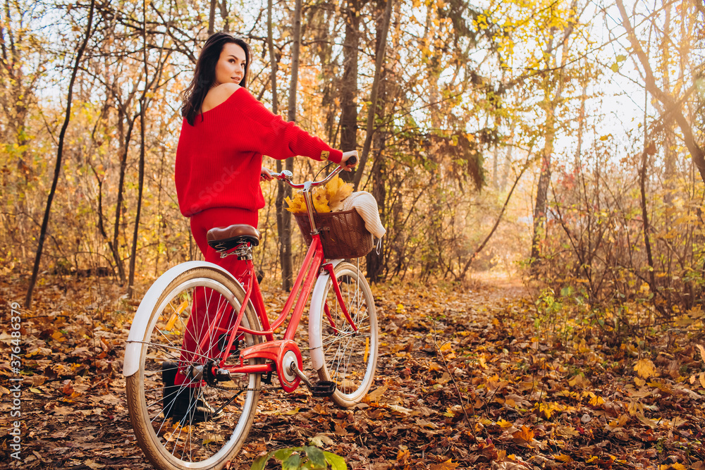 beautiful girl - brunette walks in the autumn forest on a bicycle, golden autumn