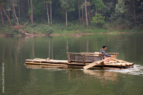 Thai rower waterman rowing bamboo rafts in Pang Ung lake for service travelers people travel visit Pang Oung or Switzerland of Thai at Ban Rak Thai on February 28, 2020 in Mae Hong Son, Thailand