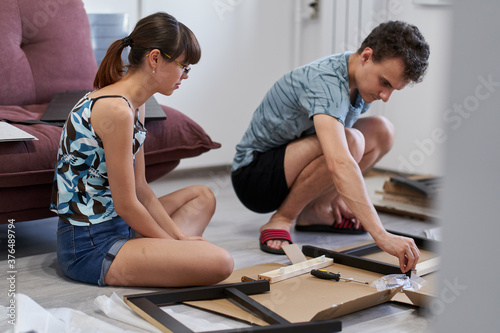 Young couple assembling their furniture